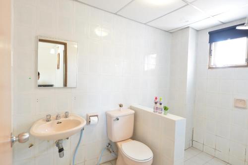 Kijal Apartment في كِجال: حمام ابيض مع مرحاض ومغسلة