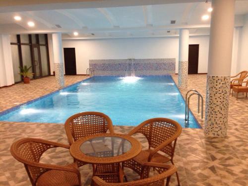 a large swimming pool with chairs and a table at Nairi Hotel in Jermuk