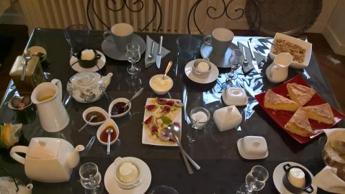 a black table with food and dishes on it at Chambres et table L' échappée in Bouvesse-Quirieu