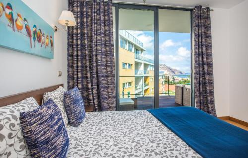 a bedroom with a bed and a large window at The Bay View - by LovelyStay in Funchal