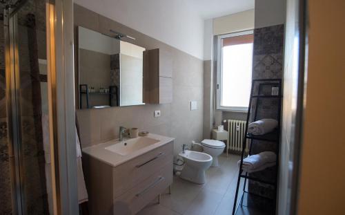 uma casa de banho com um lavatório, um WC e um espelho. em Residenza Viale Mentana em Parma