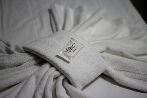 a white towel on top of a bed at Luz Hotel in Goiânia