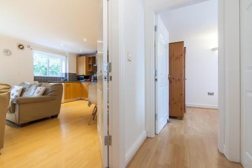 a living room with a couch and a kitchen at Rest & Recharge - Birley View in Manchester