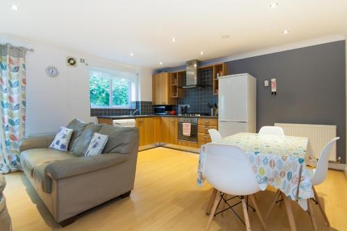 a living room with a couch and a table and a kitchen at Rest & Recharge - Birley View in Manchester