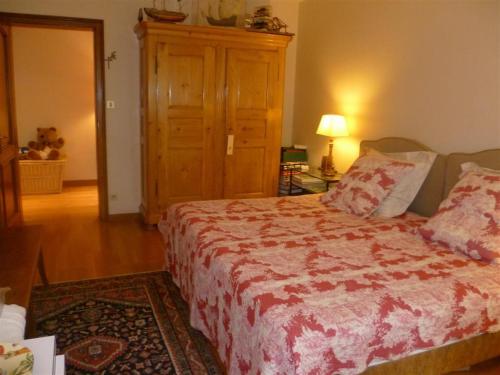 a bedroom with a bed with a red and white blanket at Bois Joli de la Freyère in Hindisheim