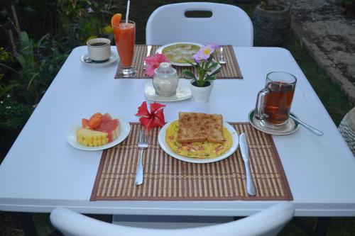 a white table with plates of food on it at Master Homestay in Amed