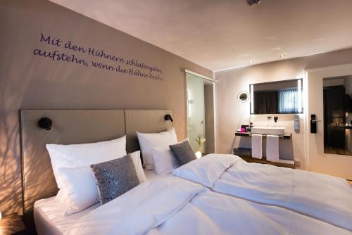 a bedroom with a large white bed and a sink at LIONO BoutiqueHotel in Goslar