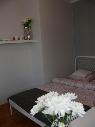una camera con un letto e un tavolo con fiori bianchi di Pokój Uniejów a Uniejow