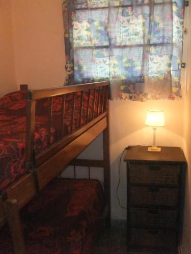 ein Schlafzimmer mit einem Etagenbett und einem Tisch mit einer Lampe in der Unterkunft Comodo Chalet en Gesell in Villa Gesell