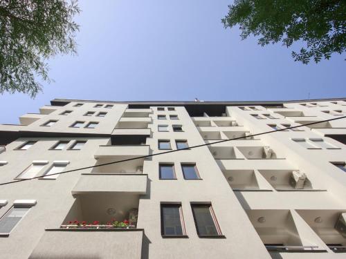 a tall white building with windows on the side at Moodeight Apartments in Skopje