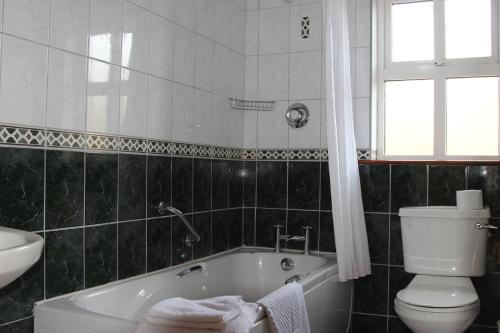 uma casa de banho com uma banheira, um WC e um lavatório. em Inch Beach Cottages em Inch