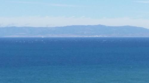 a view of the ocean with mountains in the distance at Hotel Le Gardenia (ex Lutetia) in Tangier