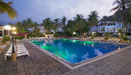 een groot zwembad met stoelen en palmbomen bij Vista Playa de Oro Manzanillo in Manzanillo