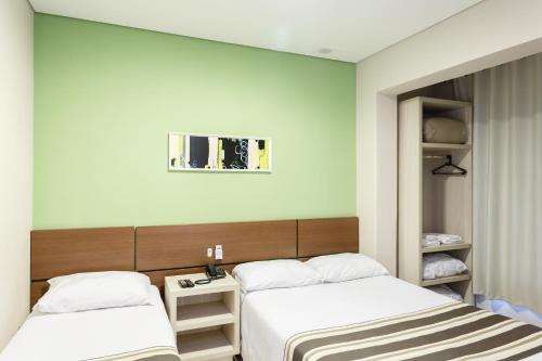Un pat sau paturi într-o cameră la Hotel Sol By MRHotelaria