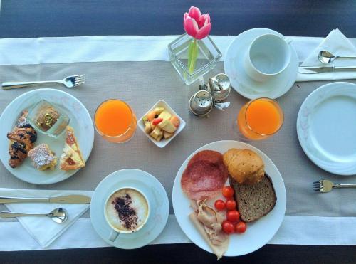 a table with plates of breakfast food on it at Piccolo Hotel in Malcesine