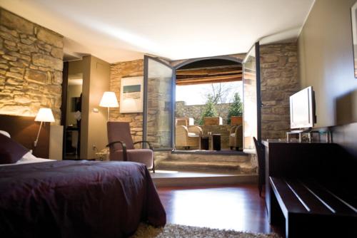 a bedroom with a bed and a living room at Mas Albereda in Sant Juliá de Vilatorta