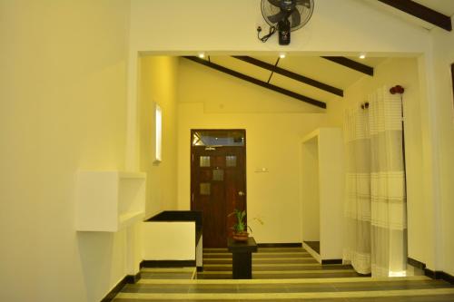 a hallway with a door and a potted plant at Midigama Holiday Inn in Midigama