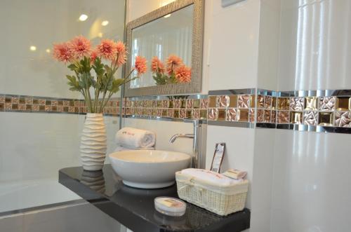 baño con lavabo y jarrón con flores en Hotel Remanso, en Chimbote