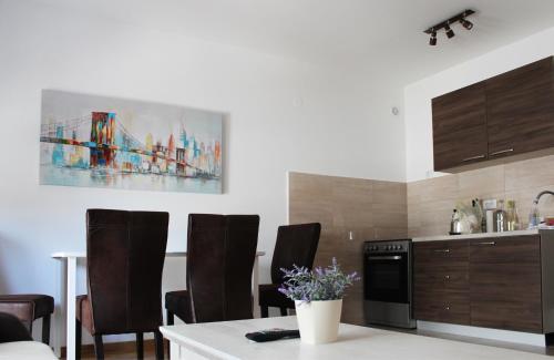 une cuisine avec des chaises, une table et un tableau dans l'établissement Apartment Leonis, à Belgrade