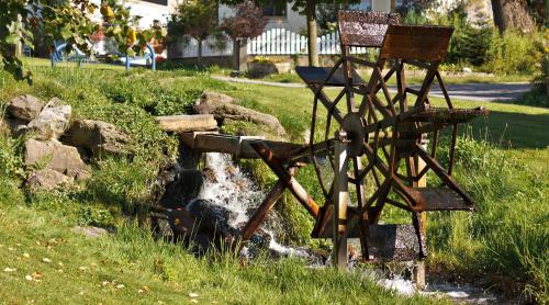 an old chair sitting next to a small creek at Gasthof Meindl in Arrach