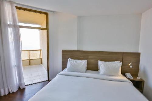a bedroom with a large bed and a window at Hotel Orizzonte Niteroi by Atlantica in Niterói