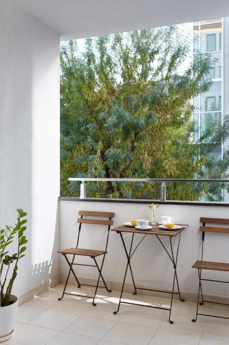 a table and chairs on a balcony with a tree at Moodeight Apartments in Skopje