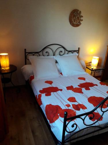 une chambre avec un lit avec des fleurs rouges dessus dans l'établissement Appart Ensoleillé Proche Remparts, à Avignon