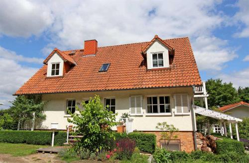 Kolonie EcktanneにあるFerienwohnungen Waren SEE 9190のオレンジ色の屋根の白い家