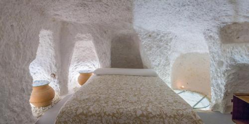 
a bed in a room with a wall covered in snow at Casa Cueva Las Tinajas de Naya in Alcalá del Júcar
