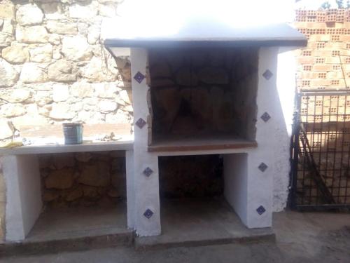 two benches sitting next to a stone wall at La Herreria de Esteban in Cuevas Labradas