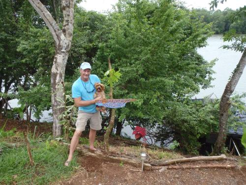 a man is holding a dog in his arms at Beached Bungalow Overlooking the Pacific Ocean in Boca Chica