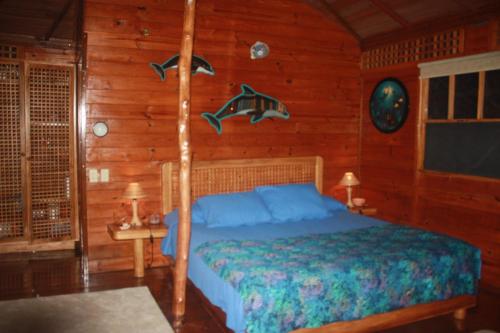 a bedroom with a bed in a wooden room at Beached Bungalow Overlooking the Pacific Ocean in Boca Chica
