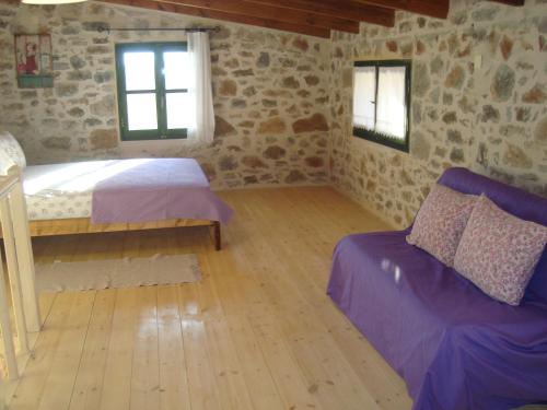 a room with a bed and a couch and two windows at House in Organic Orgon farm in Apóstoloi