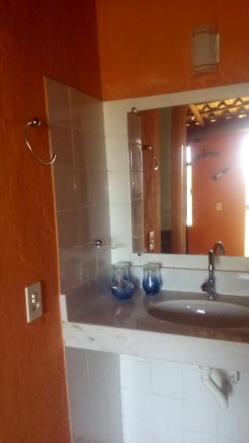 une salle de bain avec un lavabo et un miroir dans l'établissement Pousada Quiosque do Professor, à Macacos