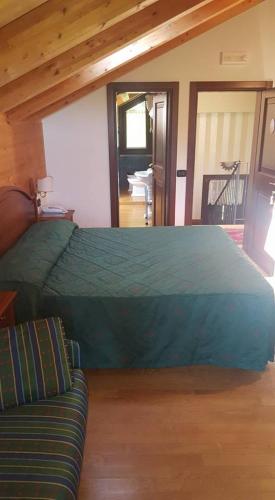 een slaapkamer met een groot bed en een bank bij Albergo Carpe Diem in Ligonchio
