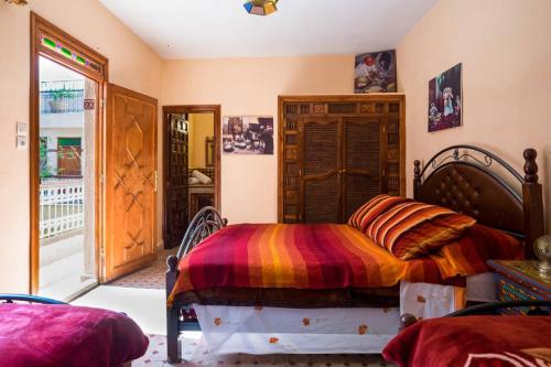 a bedroom with a bed with a colorful blanket at Riad Les Chrifis Navette Aéroport 24 sur 24 in Fès