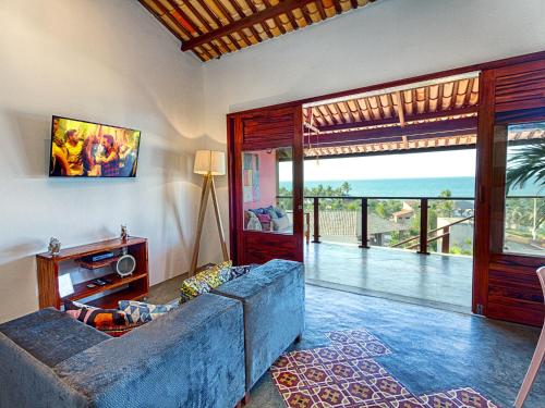 a living room with a couch and a view of the ocean at Castelo Pink Boutique Hotel in Uruau