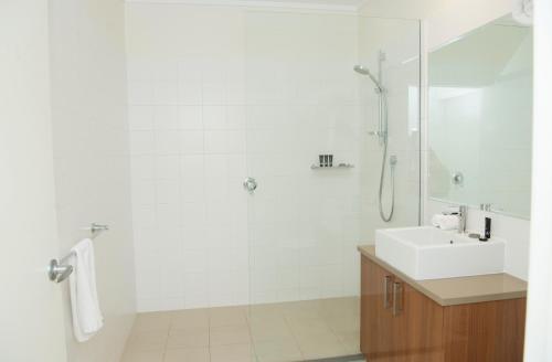 a white bathroom with a sink and a shower at The Griff Motel in Griffith