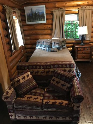 a bedroom with a bed in a log cabin at Gwin's Lodge & Roadhouse in Cooper Landing