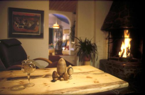 a table with a wine glass and a fireplace at STF Hotel & Hostel Persåsen in Persåsen