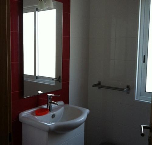 La salle de bains est pourvue d'un lavabo et d'un miroir. dans l'établissement A Casa Da Avenida, à Madalena