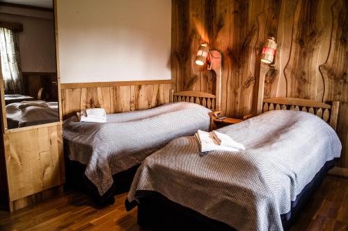 a hotel room with two beds and a mirror at STF Hotel & Hostel Persåsen in Persåsen