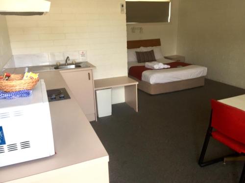 a hotel room with a bed and a desk at Huskisson Bayside Resort in Huskisson