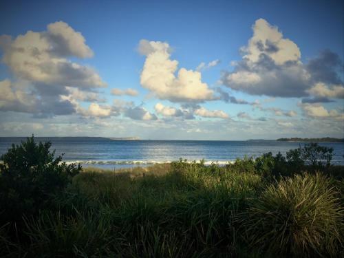 a beach with the ocean and clouds in the sky at Huskisson Bayside Resort in Huskisson