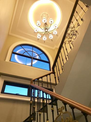 a coffered ceiling with a chandelier and stairs at A Villa Hua Hin Hotel in Hua Hin