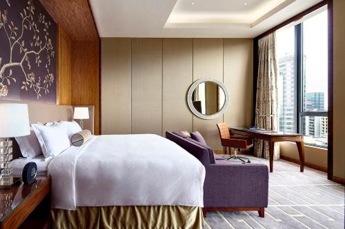 una stanza d'albergo con un letto e uno specchio di The Royal Garden a Hong Kong