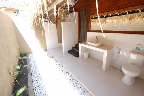 a bathroom with a toilet and a sink at Paradesa Living in Gili Trawangan