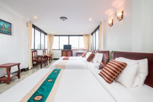 a hotel room with two beds and a desk at Angkor Udom Guesthouse in Siem Reap