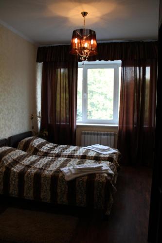 a bedroom with a bed and a window and a chandelier at Hotel Meduza in Kharkiv