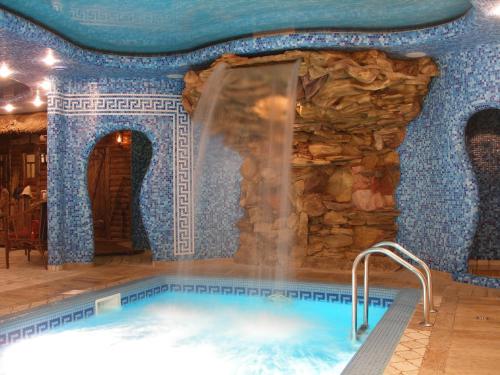 a swimming pool in a room with a stone wall at Hotel Meduza in Kharkiv